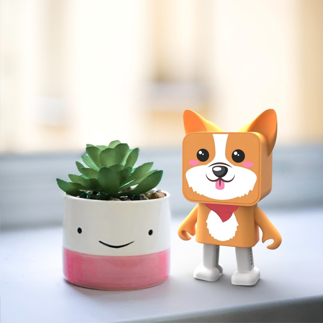 Słodka figurka głośnik bezprzewodowy corgi obok doniczki z zieloną rośliną na białym tle