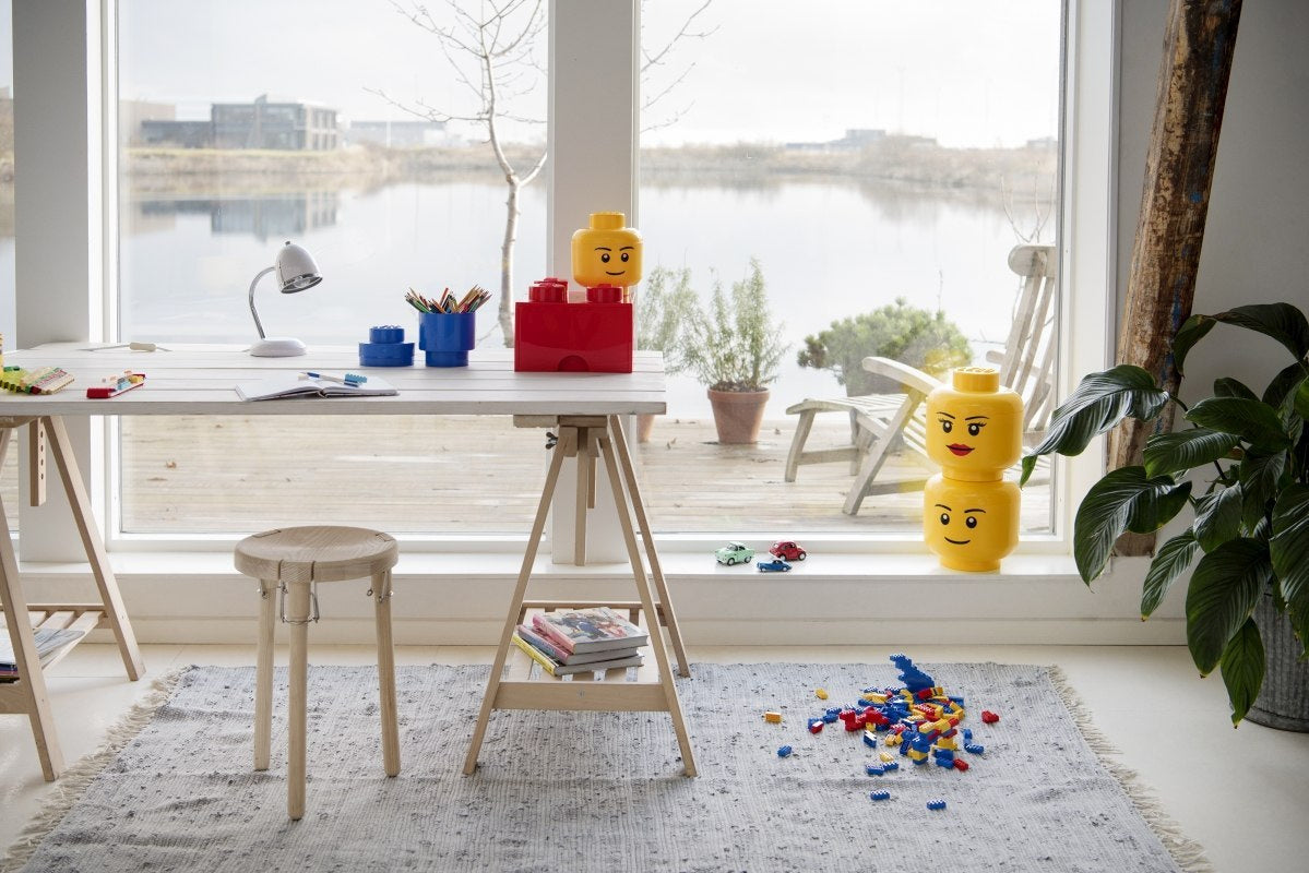 Pojemniki LEGO głowa dziewczynka w jasnym pokoju z dużym oknem i biurkiem do zabawy dziecięcej