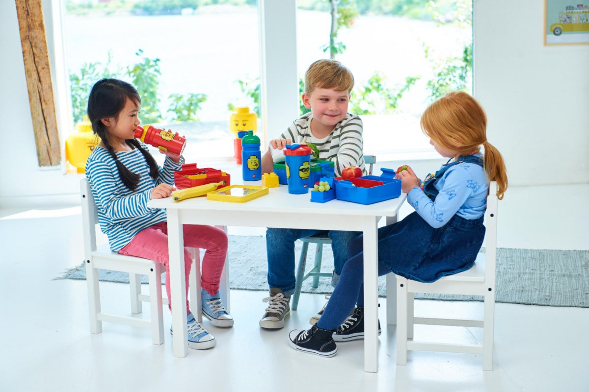 Lunchbox LEGO chłopięcy na białym stole z dziećmi podczas zabawy i jedzenia