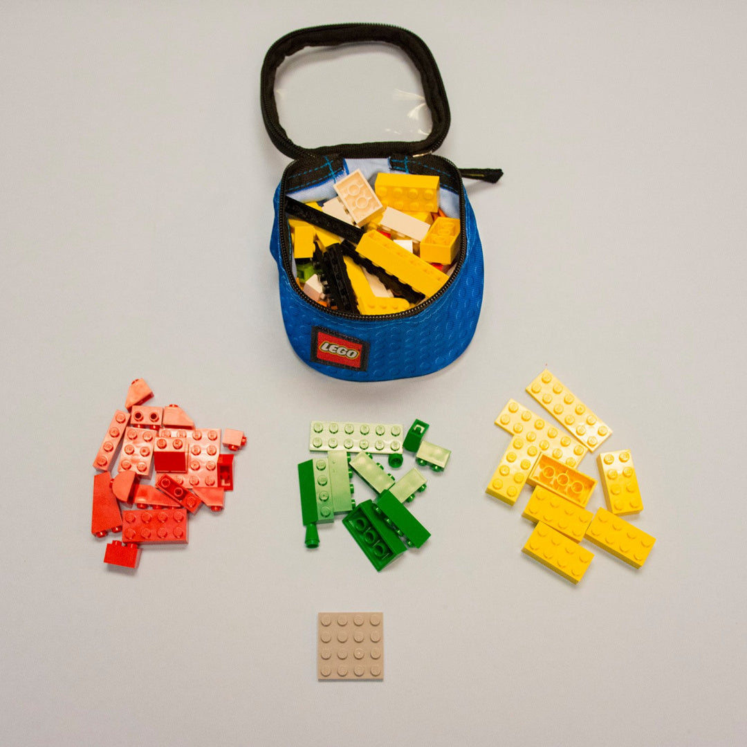 Organizery LEGO na klocki w niebieskim etui z podziałem na czerwone, zielone i żółte klocki