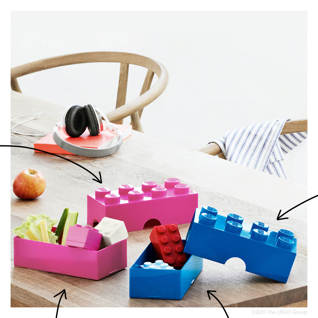 lunchbox klocek LEGO różowy i niebieski pudełka na przekąski na drewnianym stole z warzywami i jabłkiem