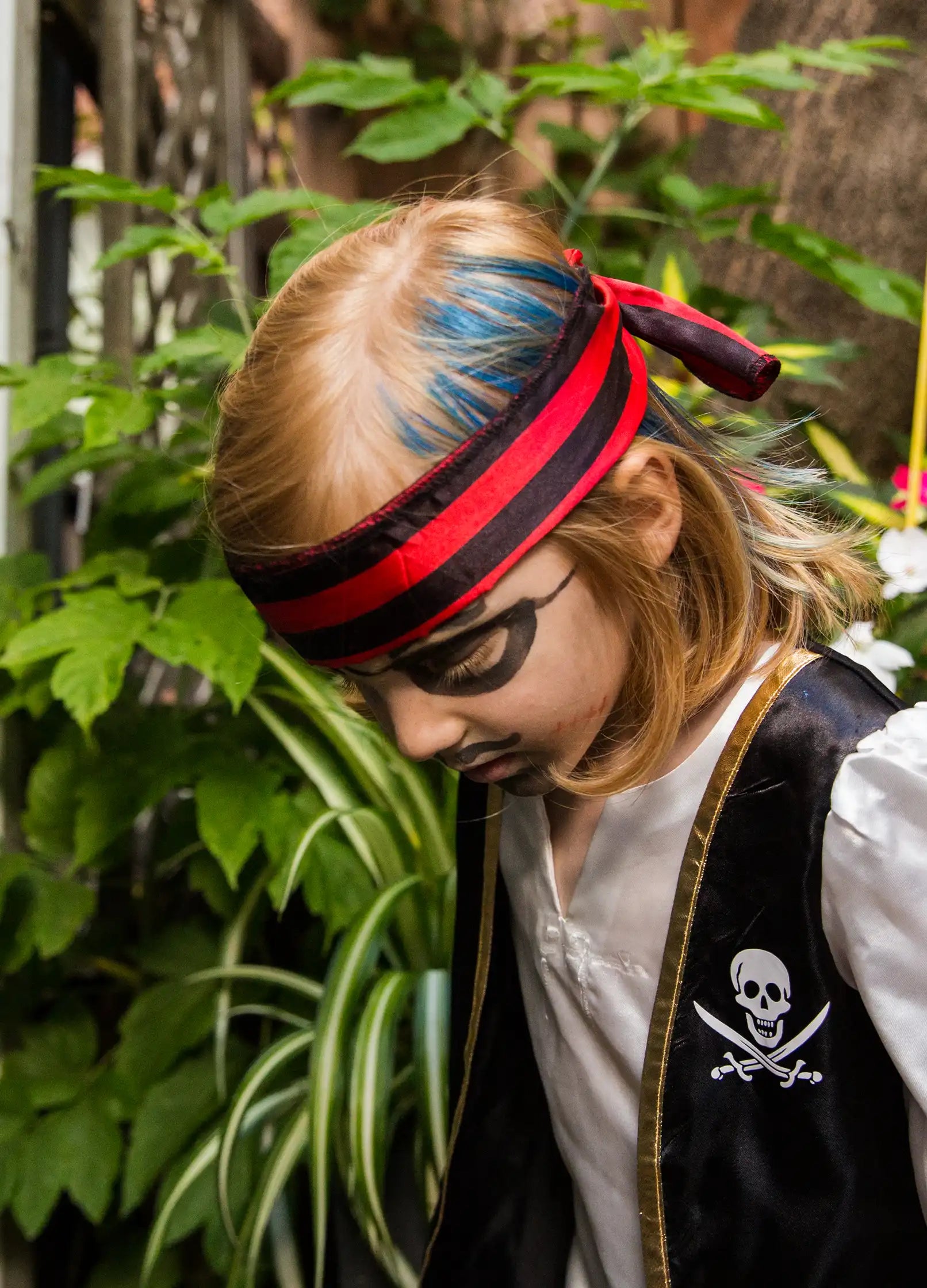 Dziecko przebrane za pirata z niebieska maskara do włosów dla dzieci i makijażem na twarzy